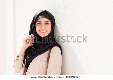 stock-photo-smiling-girl-in-hijab-covering-her-eyes-with-happiness-in-dubai-marina-406263466